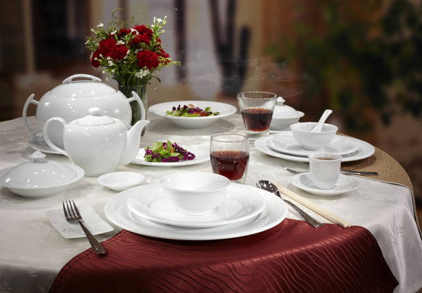 Served restaurant table with white dishes, cutlery and wineglasses  - Photo, Image