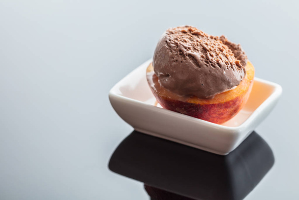 Dessert ice cream on peach, dark background with reflection - Photo, Image