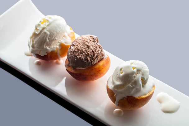 Dessert ice cream on peach, dark background with reflection - Photo, image