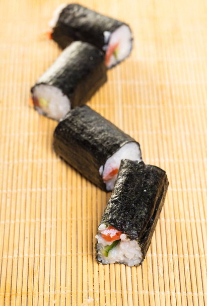 Japanese food. Cut rolls on a bamboo mat - Fotoğraf, Görsel