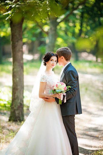 Bruid en bruidegom op hun trouwdag in park   - Foto, afbeelding