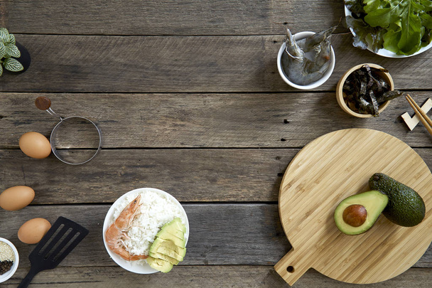 Shrimp Sashimi Reis Poke Schüssel mit Avocado sauber und ausgewogen gesundes Nahrungsmittelkonzept. Auf dunklem Holzhintergrund, Ansicht von oben - Bild - Foto, Bild