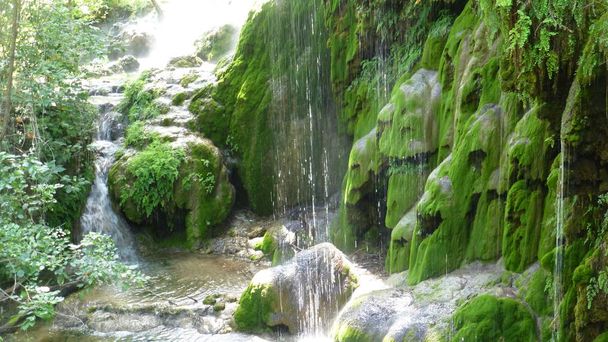 cascades d'eau coulant sur des roches moussues
  - Photo, image
