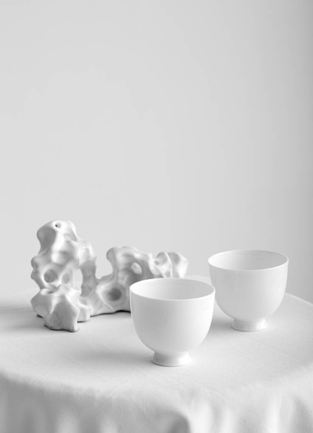 白い背景に隔離された白いカップを持つテーブルのクローズアップビュー - 写真・画像
