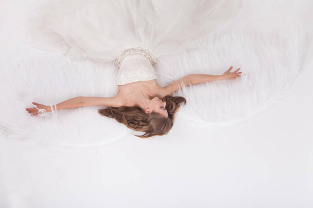 Girl in white dress with angel wings on white background. Angel-woman - Photo, Image