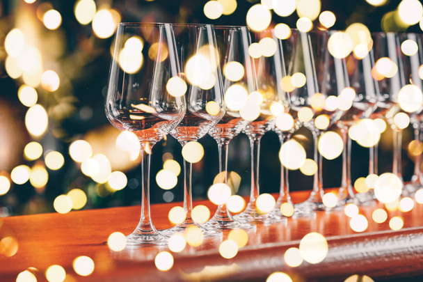 Kieliszki z rzędu do wina. Bufet celebracja tabeli z degustacją wina. Koncepcja celebracja, rozrywki i nocnego życia. Poziome, zimno nastrojony obrazu, jasne światła bokeh tło - Zdjęcie, obraz