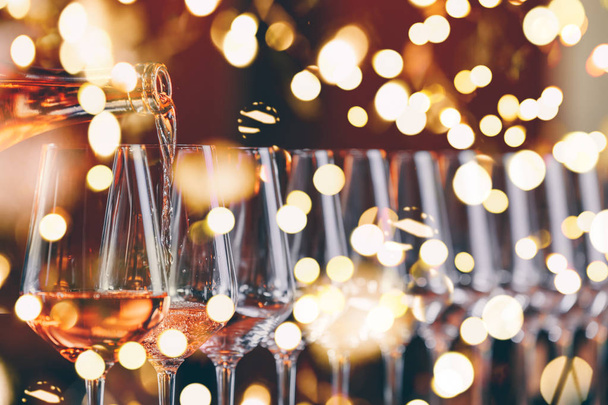Borospohár egy sorban. Ömlött a bort. Svédasztalos tábla ünnepe a borkóstolás. Éjszakai élet, ünneplés és szórakozás koncepció. Vízszintes, hideg tónusú kép, élénk fények bokeh háttér - Fotó, kép