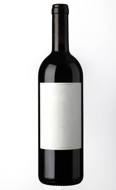 Бутылка красного вина с незаполненной этикеткой на белом фоне
 - Фото, изображение
