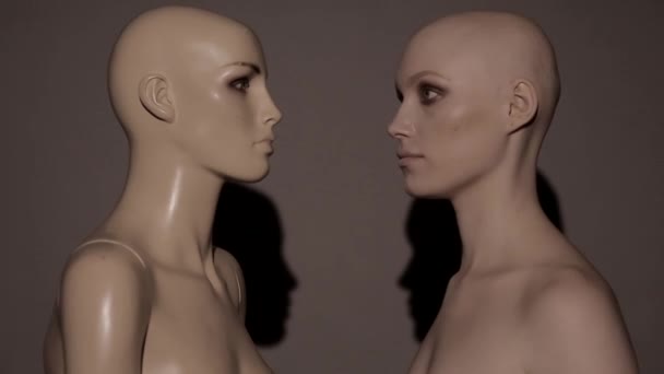 Mannequin and same girl look at each other on a simple background, girl laughing, concept video - Footage, Video