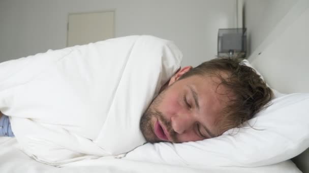 άρρωστος νεαρός άνδρας με πυρετό κοιμισμένοι στο κρεβάτι, που καλύπτεται με μια κουβέρτα - Πλάνα, βίντεο