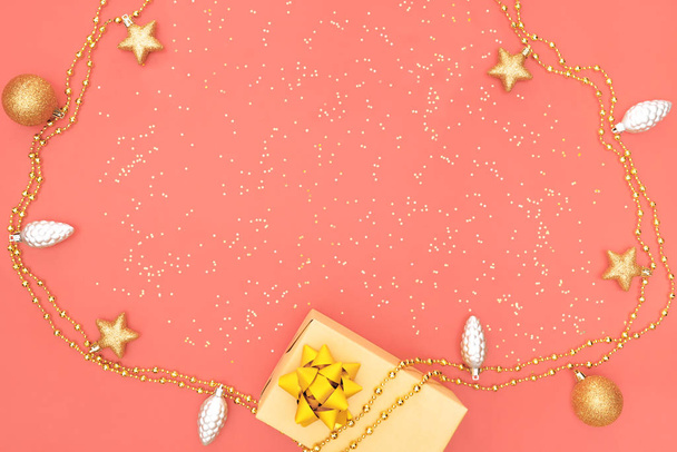 geschenkdoos of geschenkdoos met gouden ster, bel en bal op roze levende koraal achtergrond voor verjaardag, kerst of huwelijksceremonie - Foto, afbeelding