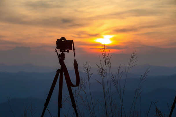 silhouette della fotocamera su un treppiede e il bellissimo cielo serale in campagna
. - Foto, immagini