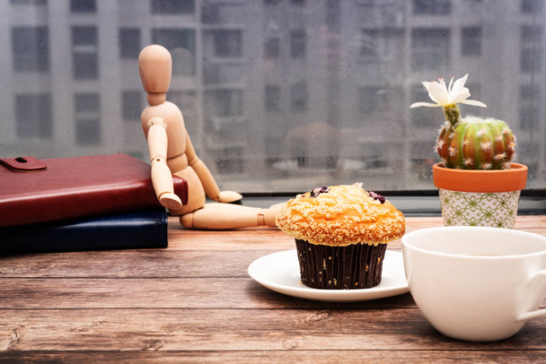 Понеділок Ранкова концепція, гарячий чай і кекс на дерев'яному робочому місці
 - Фото, зображення