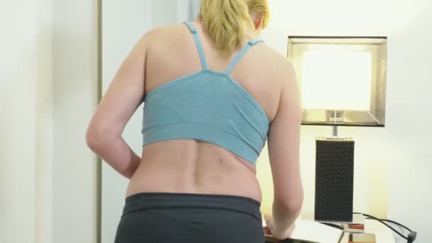 El concepto de sobrepeso y pérdida de peso. Una mujer se mide a sí misma con una cinta métrica en el dormitorio. Mirándose en el espejo
 - Metraje, vídeo