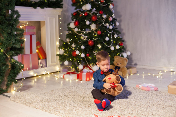chłopiec otwiera prezentuje nowego roku Garland choinki bożonarodzeniowe - Zdjęcie, obraz