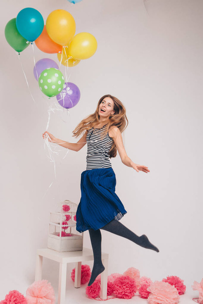 la chica vuela sosteniendo los globos. volando un globo. fiesta mágica. magia práctica
 - Foto, imagen