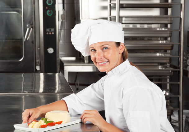 Жіночий кухар з посудом за лічильником
 - Фото, зображення