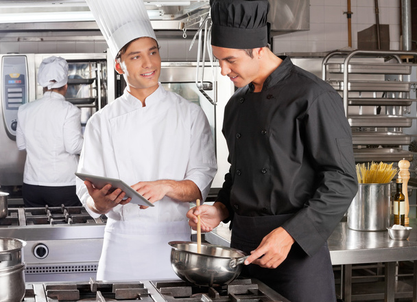 Male Chef Assisting Colleague In Preparing Food - Photo, image