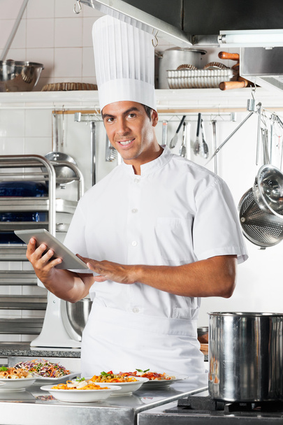 Young Chef Holding Tablet With Pasta Dishes At Counter - Foto, Bild