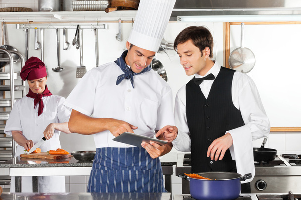 Waiter And Chef Using Digital Tablet In Kitchen - Foto, afbeelding