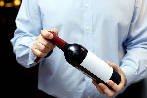 male sommelier is checking and testing red wine and making notes - Foto, Imagem