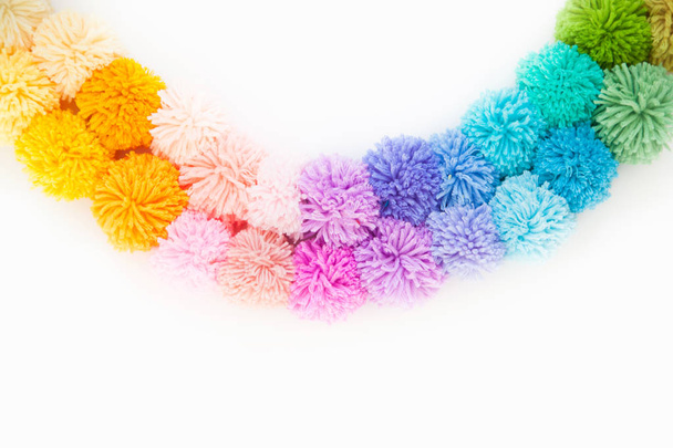 Garland and a wreath of colored pompons. Bright yarn pastel colors. - Foto, Imagen