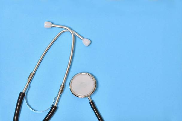 Black stethoscope isolated on blue background - Photo, Image