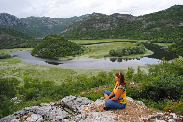 Chica meditando en el río Crnojevica
 - Foto, Imagen