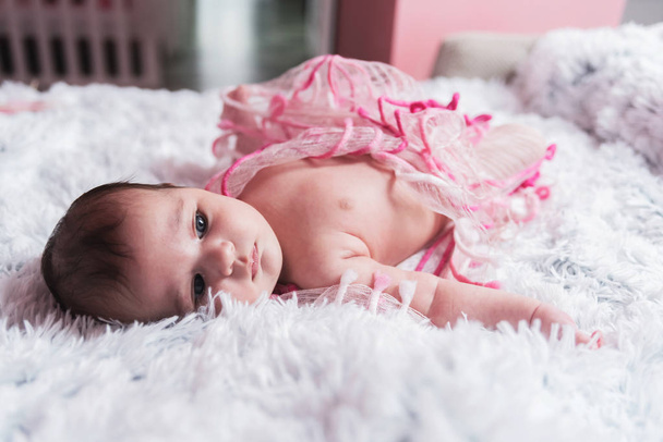 かわいい眠い赤ちゃん女の子素敵な温かく明るいベッドルームで毛皮のようなふわふわの毛布に横たわって - 写真・画像