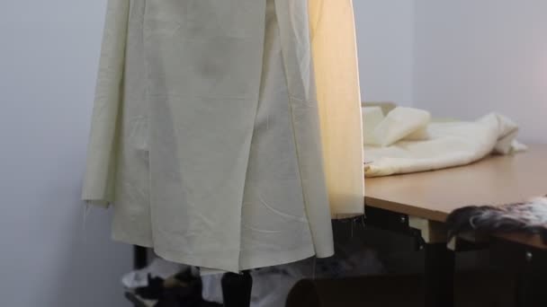 Jaqueta na fase inicial de alfaiataria é vestida em um manequim em uma oficina de costura
 - Filmagem, Vídeo