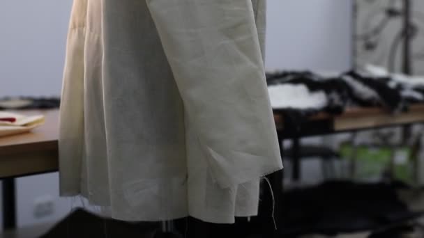 Jacke in der Anfangsphase der Schneiderei ist auf einer Schaufensterpuppe in einer Näherei gekleidet - Filmmaterial, Video
