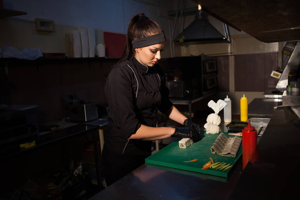 жінка готує смачні суші на кухні в ресторані
 - Фото, зображення