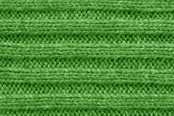 Gestrickte Textur. Musterstoff aus Wolle. Hintergrund, Kopierraum. Handgemachter Pullover, Strickwollmuster, grüner Hintergrund - Foto, Bild