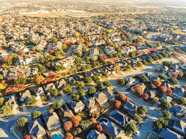 Вид с воздуха на город с красочной осенней листвы недалеко от Далласа, штат Техас, США. Флайовер пригородное подразделение с рядом жилых односемейных домов и многоквартирных домов осенью утром
 - Фото, изображение