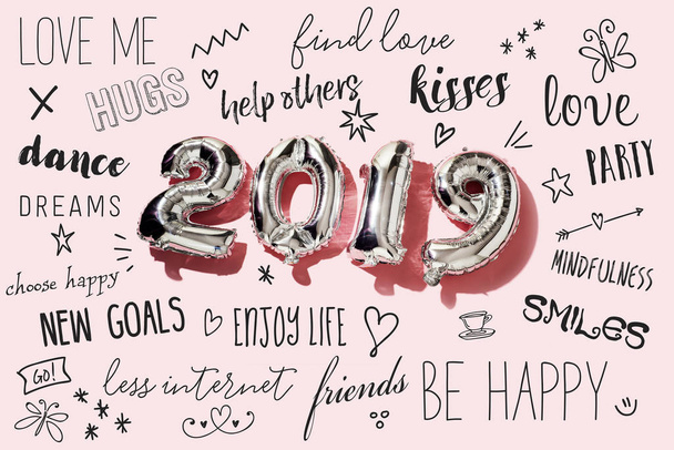 algunos globos plateados en forma de número que forman el número 2019, como el nuevo año, y algunas resoluciones de año nuevo sobre un fondo rosa
 - Foto, imagen