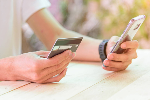 использовать кредитную карту для покупок онлайн по смартфону / держать кредитную карту для покупок онлайн по смартфону
 - Фото, изображение