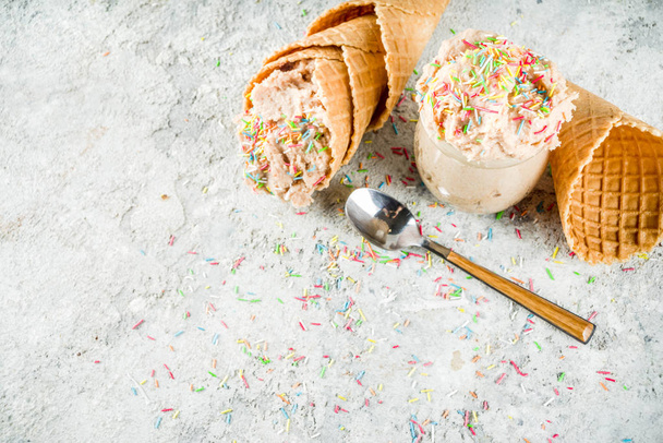Edible Raw Cookie Dough, sweet modern dessert, with waffle ice cream cones on grey stone background, copy space - Фото, зображення