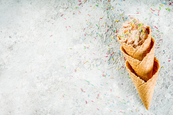 Massa de biscoito cru comestível, sobremesa moderna doce, com cones de sorvete de waffle no fundo de pedra cinza, espaço de cópia
 - Foto, Imagem
