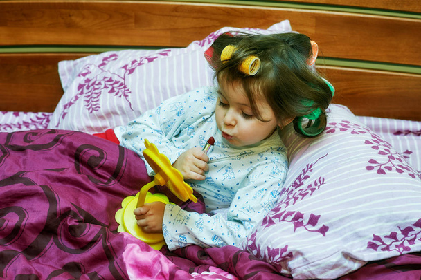 yatakta yatan curlers, küçük bir kız portresi. Sabah küçük fashionista - Fotoğraf, Görsel