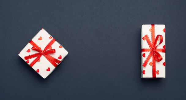коробка с подарком с изображением сердец, привязанных лентой изолировать на белом фоне. Valentine 's Day celebration concept
 - Фото, изображение