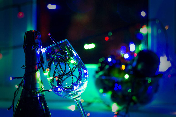 colored garland in a glass of champagne in the night the Windows in the run up to Christmas - Photo, Image