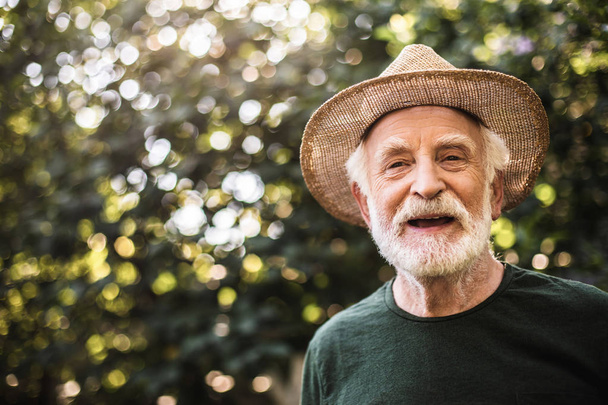 Happy old rustic man standing in garden - Fotoğraf, Görsel