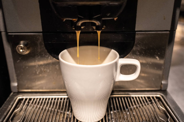 Industriële koffie-/ theevoorzieningen voorbereiding van een kopje koffie met melk. - Foto, afbeelding