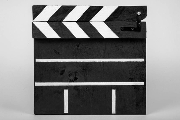 Klapky pro označení začátku film nebo videoklip z dřeva a malované černé a bílé s pruhy v uzavřené formě na bílém pozadí izolované detail - Fotografie, Obrázek