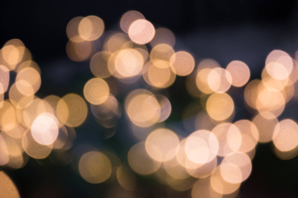Blurred golden garland. City night light blur bokeh, defocused background. Christmas and holiday abstract. - Foto, imagen