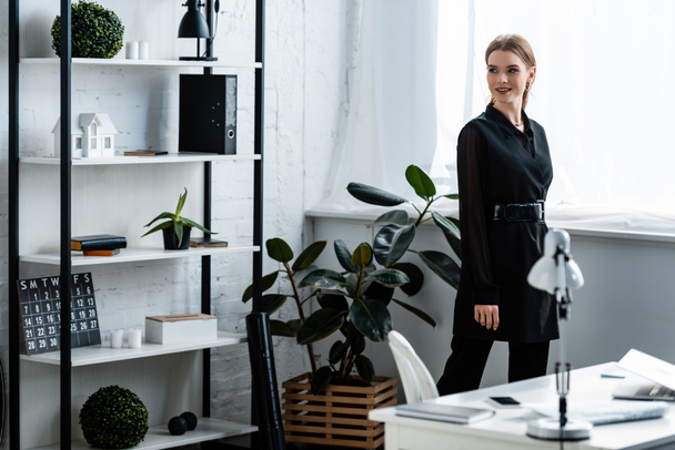 beautiful smiling woman in black clothes posing at office - Valokuva, kuva