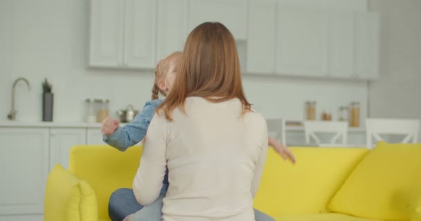 Smiling joyful little girl embracing mother happily - Πλάνα, βίντεο