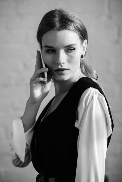 black and white photo of woman in formal wear talking on smartphone - Foto, Imagem