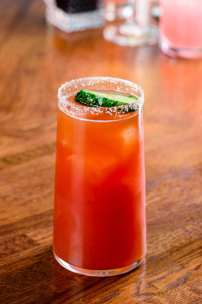 classic mexican cocktail michelada with cucumber on the bar close up - Фото, изображение