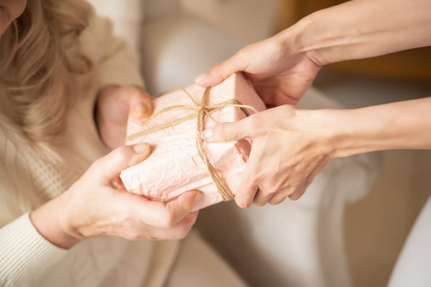 Close-up of women hands holding a gift box - Foto, Imagen